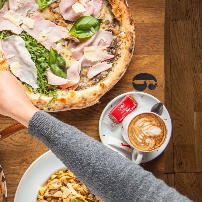 Pizza jambon-roquette accompagnée d'un cappuccino